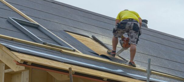 man on roof installing new roofing