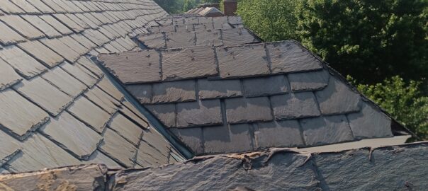 Weathered slate roof with cracked and damaged shingles
